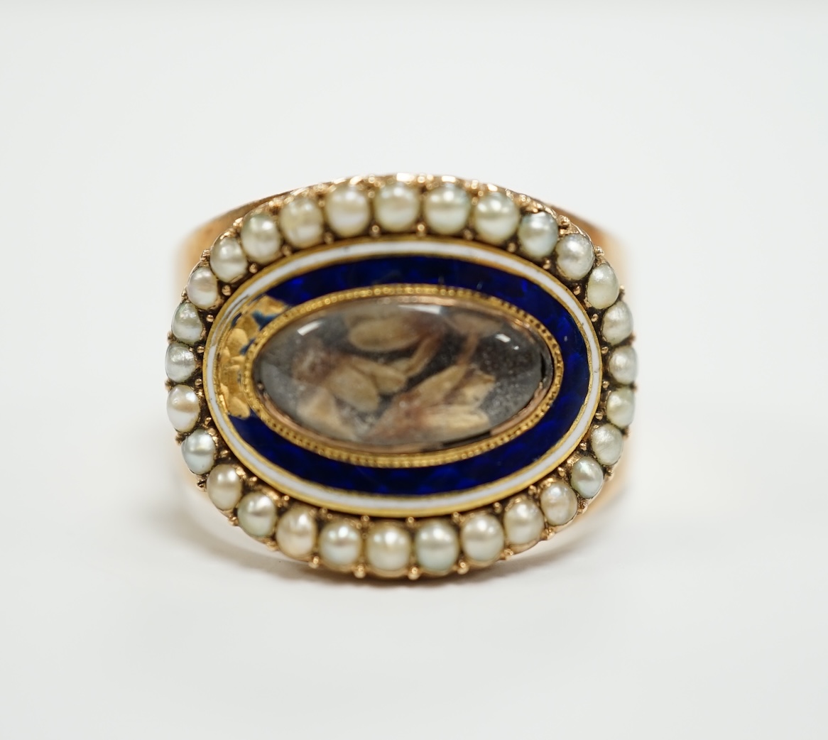 A George III yellow metal, enamel and split pearl set mourning ring, with central glazed panel and engraved inscription, 'Mary Daniels Obt. June, 1764 at 40 Willm Daniels obt 18 June, 1793 at 80', size R, gross weight 7.